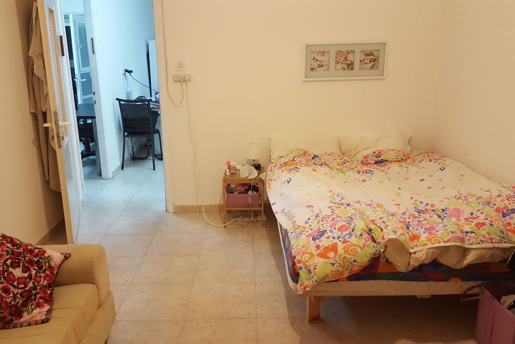 Huge decoratedt room. has nice balcony, a small sofa and a desk in it.
