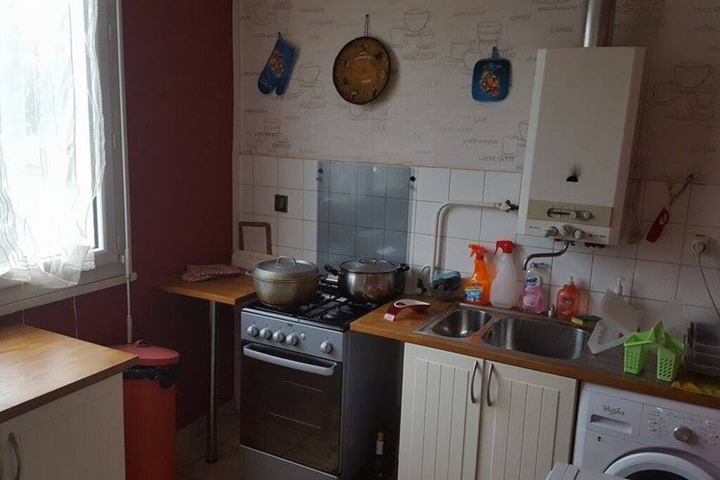 La cuisine avec gazinière, four, machine à laver et sèche linge