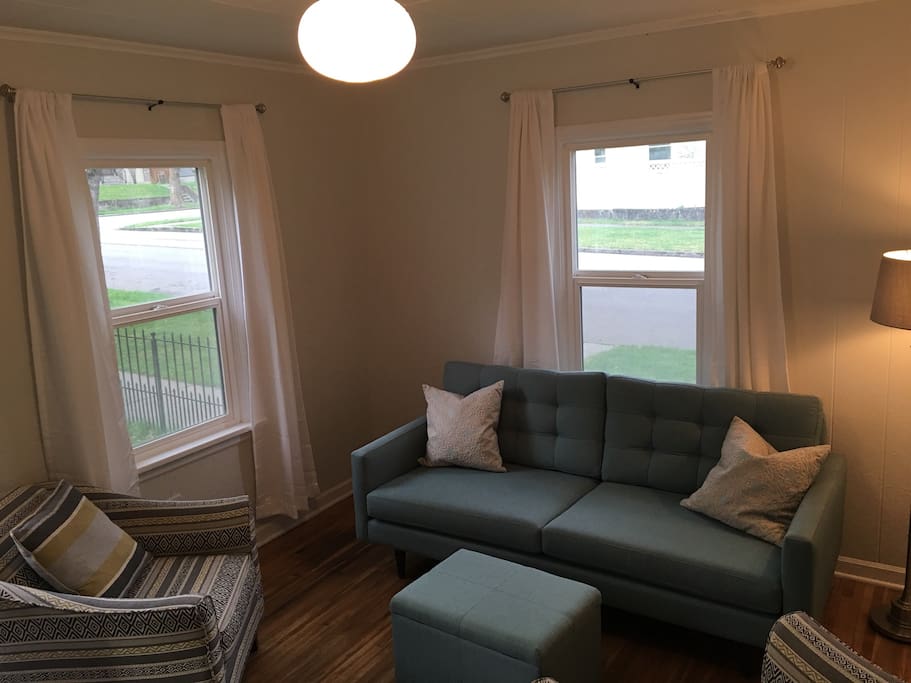 Front door enters into the living room with couch and comfortable sitting chairs.