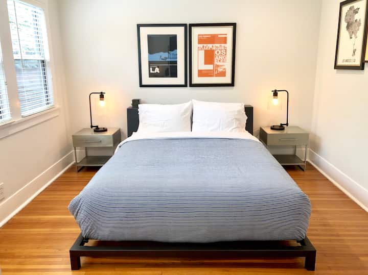 Serene master bedroom with a queen-sized platform bed and a large mirrored closet with built-ins