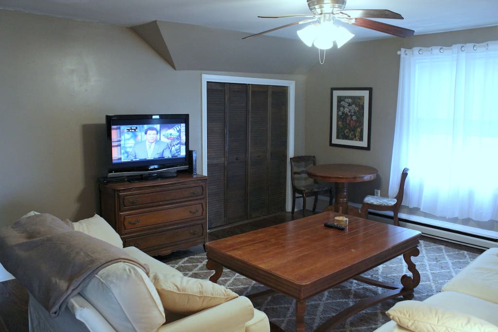 Large living room with comfortable couches, flat screen tv and cafe table