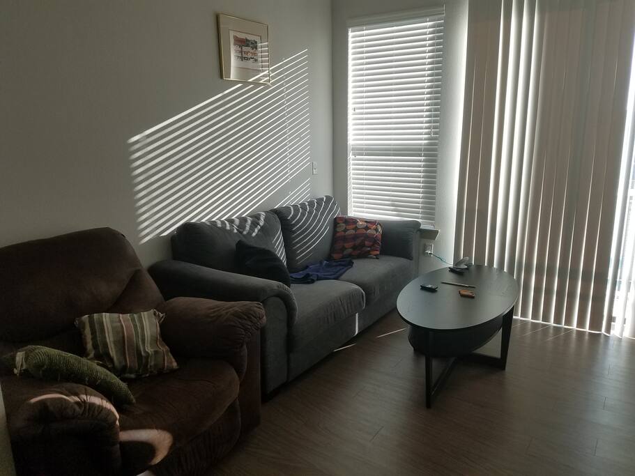Common area with couch, table, comfy chair.