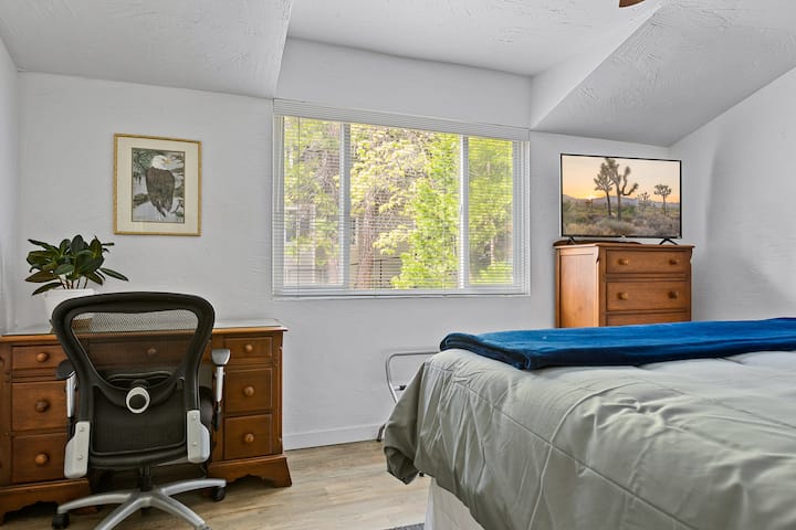 Camera da letto al piano di sotto con smart TV e scrivania