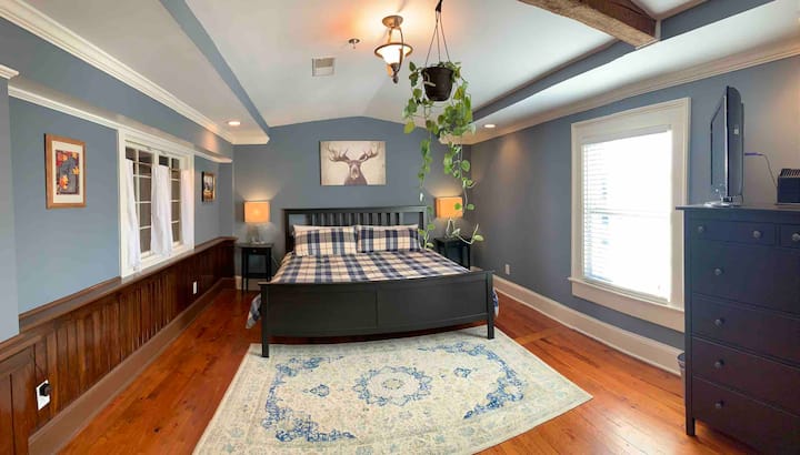 Dormitorio de invitados en la planta superior con una ventana de cascamento francés con vistas a una gran habitación.