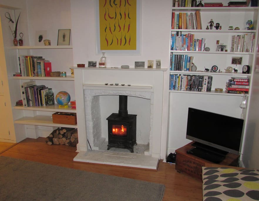 Comfortable sitting room with tv, leather sofa and wood burning stove