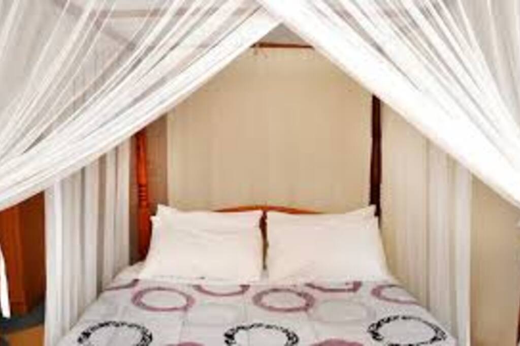 Spacious bedroom with brand new bedding and a TV and sideboard.