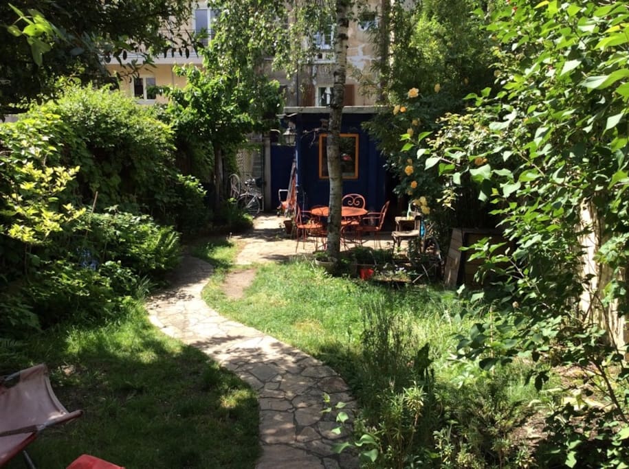 le jardin en juin avec son coin terrasse équipé pour manger dehors