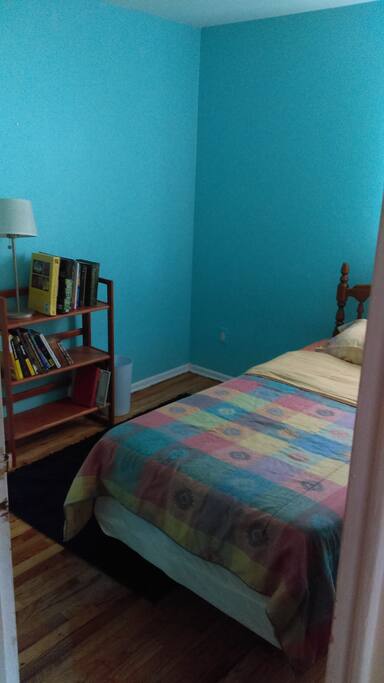 This bedroom gets beautiful light, has a closet and bureau for storage.