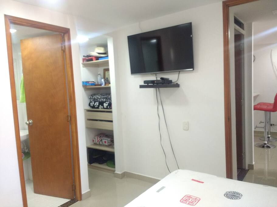 Baño al interior de la habitación, closet y smart TV.