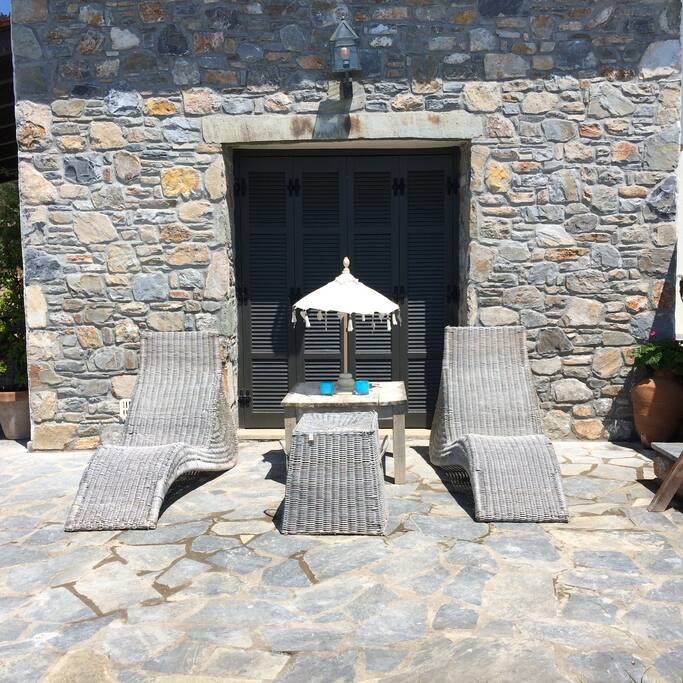 Voorkant met 2 ligstoelen. Grote parasol voorradig. Ideaal om te genieten van de zon en het uitzicht over de baai.