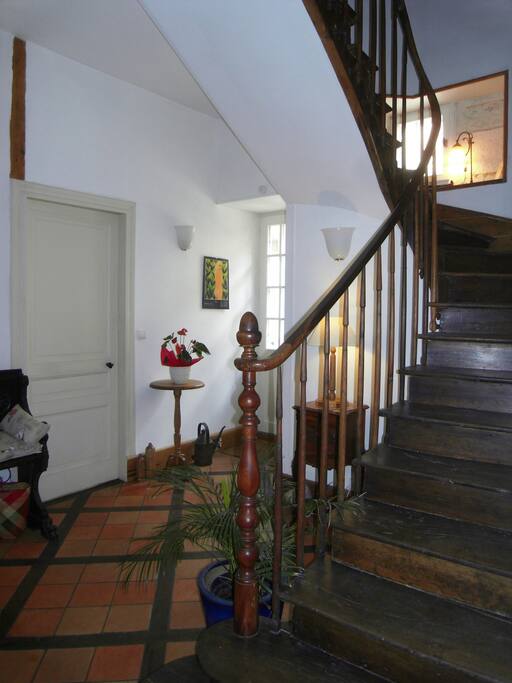 the inner hall with hand carved staircase and traditional Perigordian tomette floor inlaid with oak