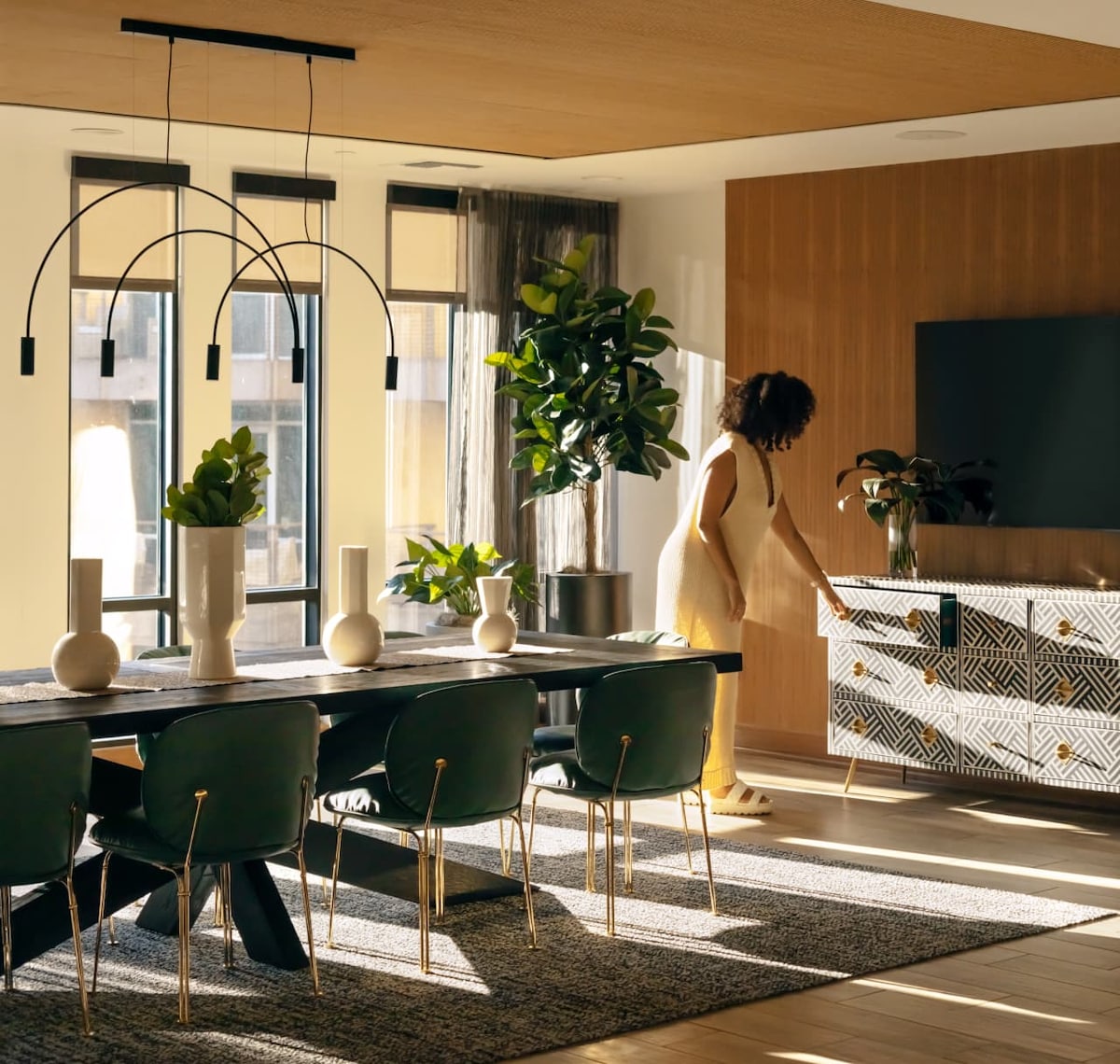 Image of a person opening a sideboard drawer in a modern, stylish dining room