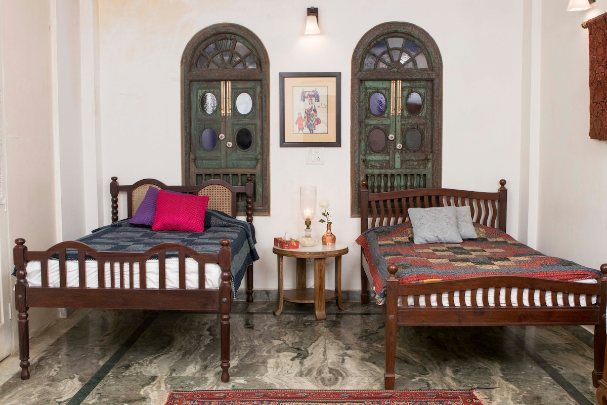 Slaapkamer 1 met grote vintage eenpersoonsbedden Het heeft een art deco werktafel en een gezellige zithoek 