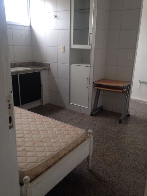 Cama de solteiro, mesa e armário.