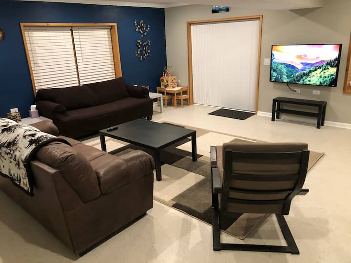 مساحة للتنزه في الطابق السفلي - تحتوي أريكة واحدة على سرير قابل للسحب كامل الحجم. تم توفير بعض الألعاب. طاولة وكراسي للأطفال.