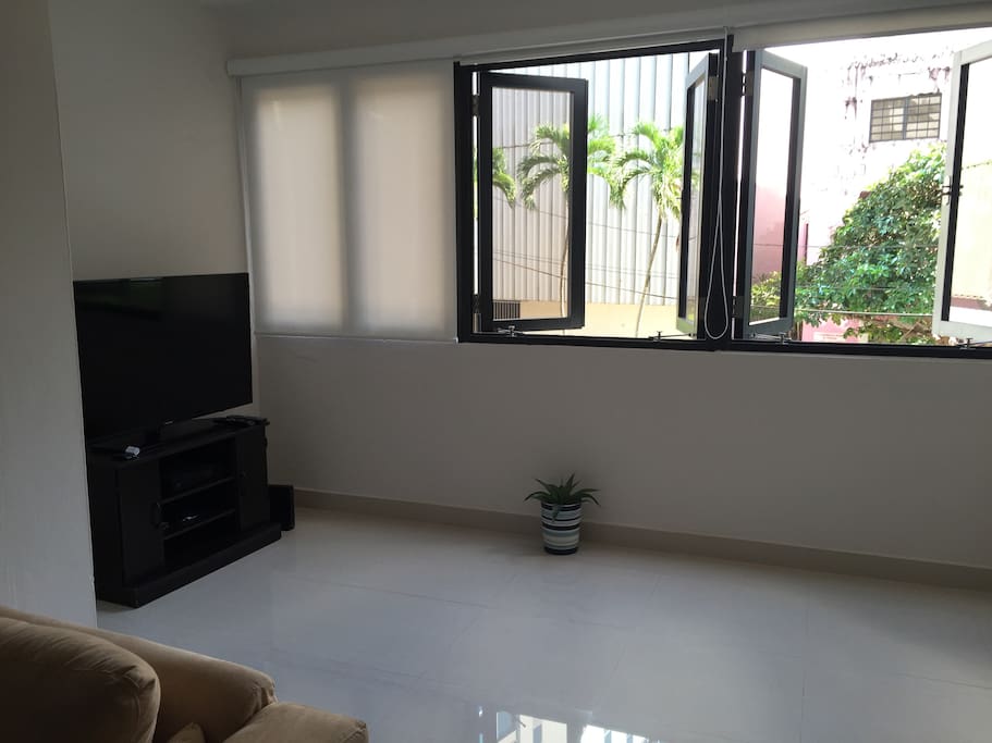 TV area. This apartment has cross ventilation from the winds that come from the almost adjacent Atlantic Ocean if these windows and rhe kitchen window are opened. Fresh air!