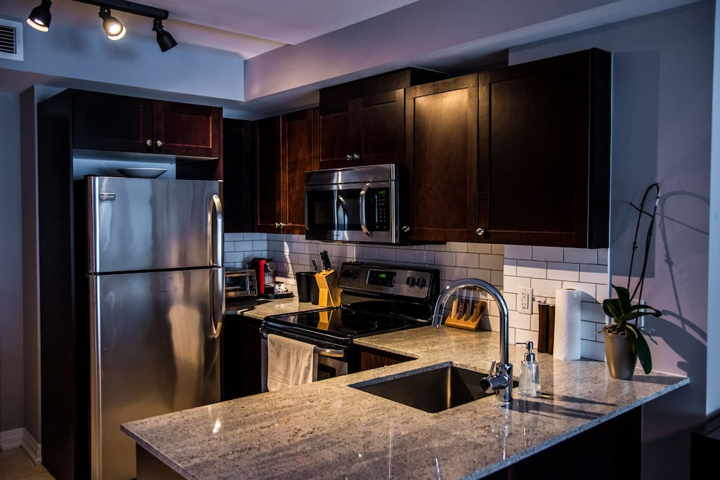 Granite and stainless steel in immaculate, fully appointed kitchen.