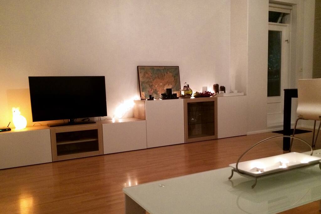 Living room seen from the sofa. At the far right you can see a door that leads to the balcony. There's a TV hooked up to cable and an AppleTV with Access to Netflix Hulu. There is free wifi in the apartment as well.