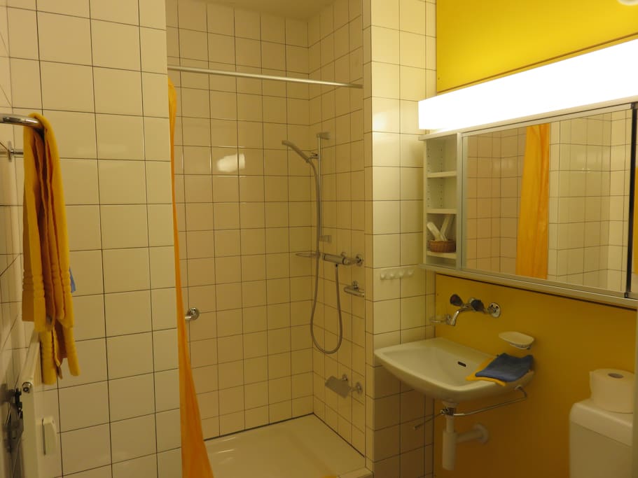 Saubere Dusche mit Badetüchern, Haartrockner, Shampoo etc.
