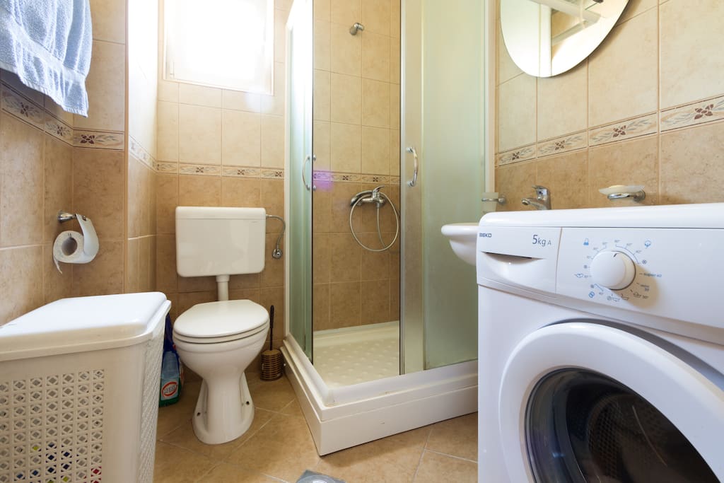 Bathroom with shower, laundry machine