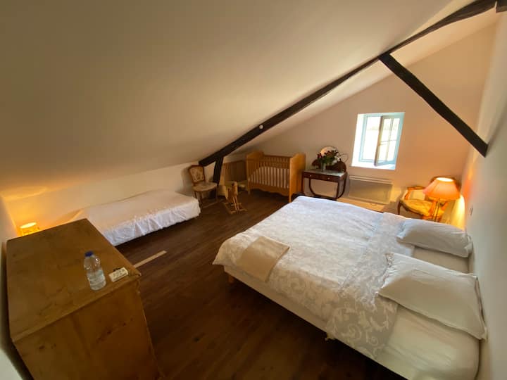 The upper room (room n°2 : 3 adults/children and 1 baby) in a charming slope with king-size bed and luxury latex mattress (2 x 90 cm), baby cot with bars , baby bath, fall barrier and single bed with box spring.