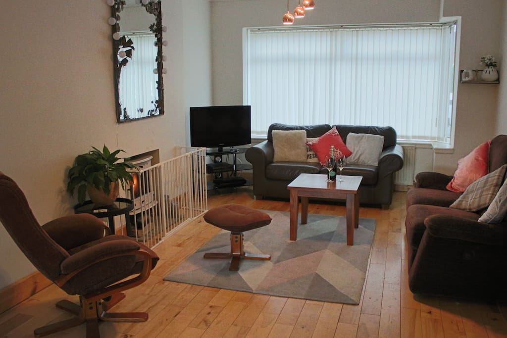 Living room with guarded stove and cable TV. Couch on the right reclines.