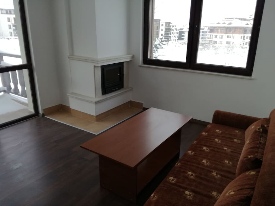 Sitting room with a balcony, fireplace and a kitchen unit