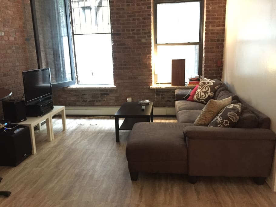 Large well-lit living space featuring a sectional sofa and cable TV