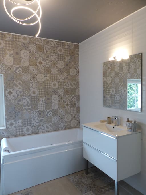 Salle de bains avec baignoire balnéo