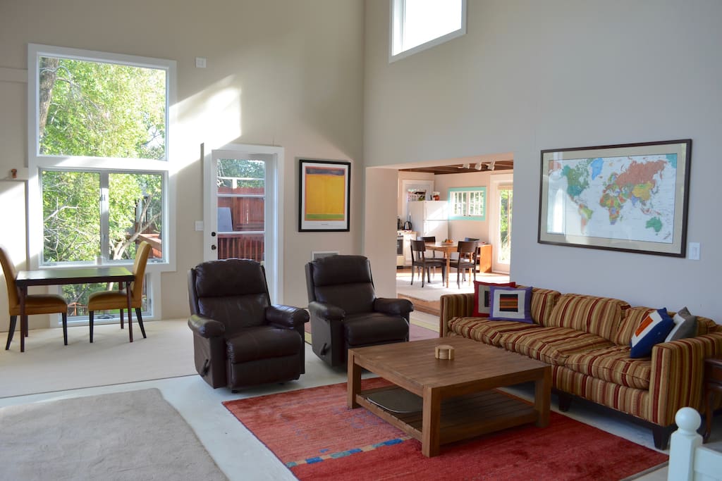 Living area with long, comfortable sofa and matching leather recliners. Office area on left and kitchen behind
