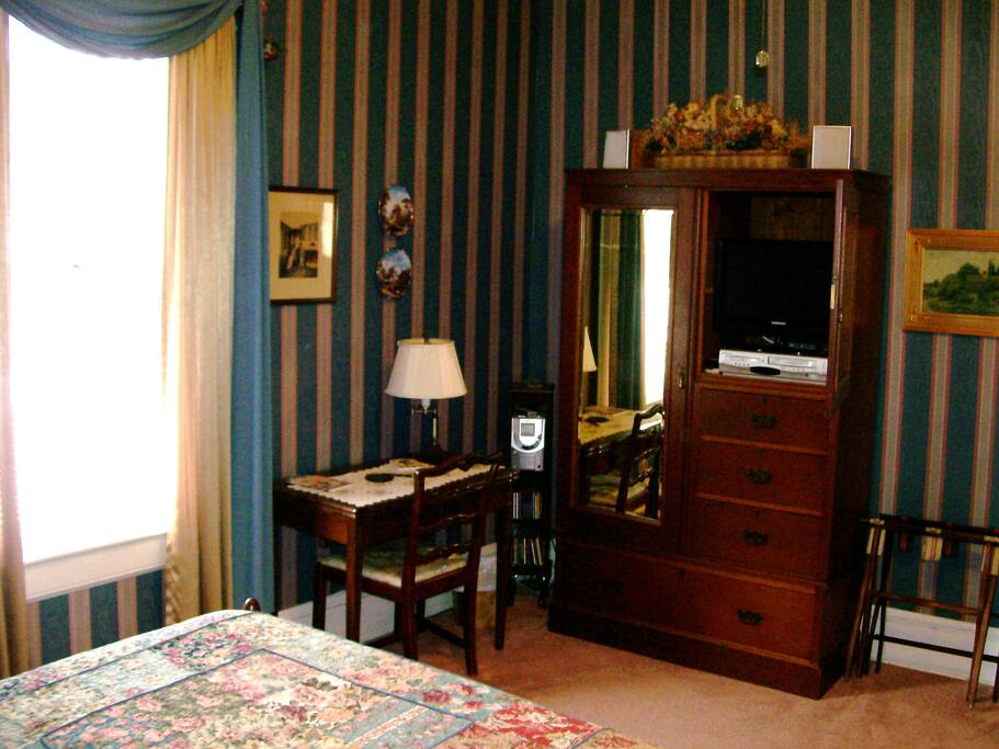 Queen size bed conveniently facing the flat screen tv, hidden in an armoire.