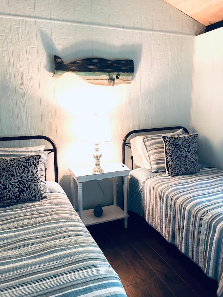 غرفة نوم تضم سريرين صغيرين