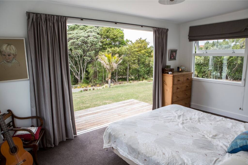 Master ensuite bedroom with doors opening onto native bush and sound of the ocean