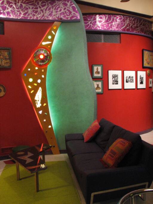 Living room with curved, Venetian plaster wall and custom light sculpture