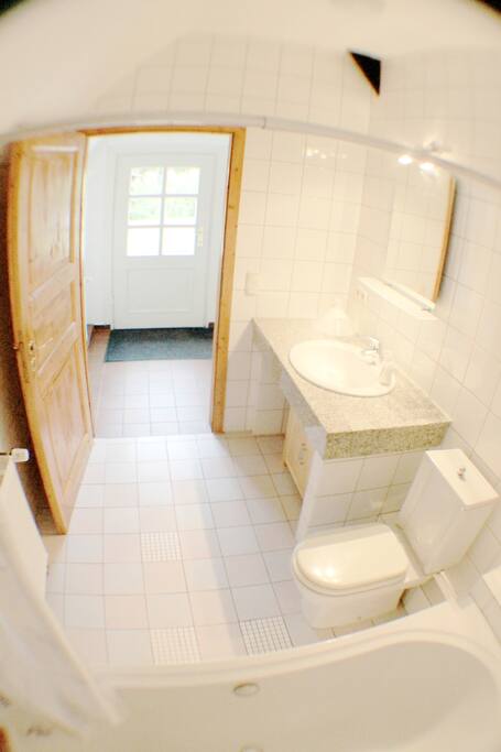 Bad mit weißem Marmor und Badewanne lädt zum entspannen ein