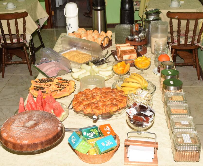 Café da manha com pães, bolo, frios, cereais, sucos