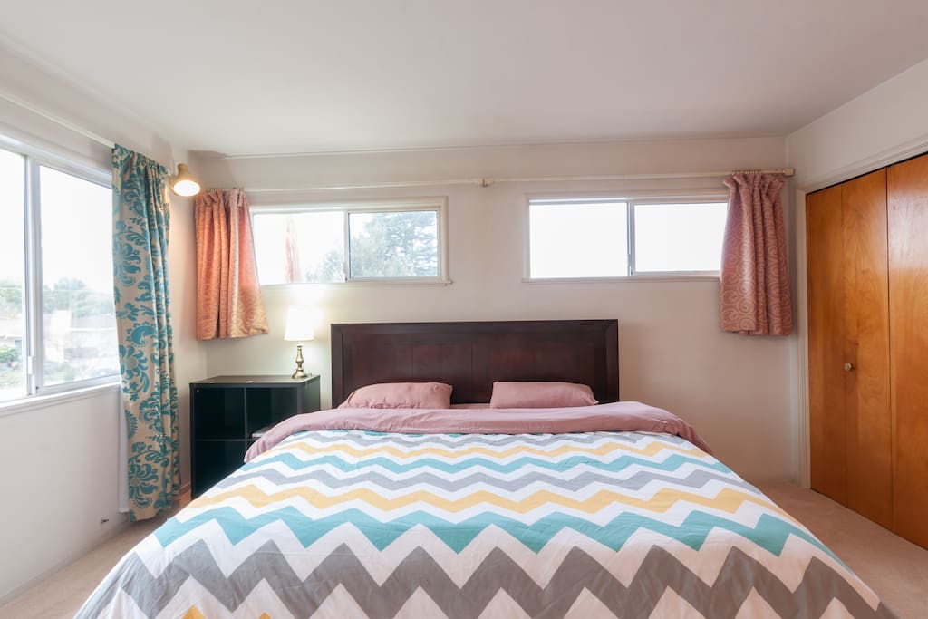 Master bedroom with king sized bed and lots of sunlight.