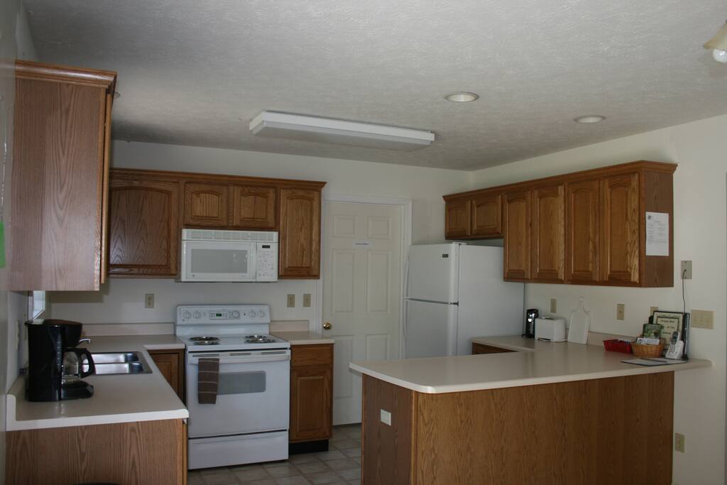 Fully-stocked kitchen with propane grill outside. Laundry room behind the door in this photo.