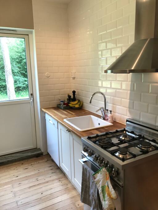 Fräscht kök med gas spis, diskmaskin, kyl och frys. Härifrån tar du dig även ut på uteplatsen.