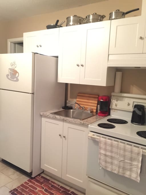 Renovated kitchen with fridge, stove and microwave