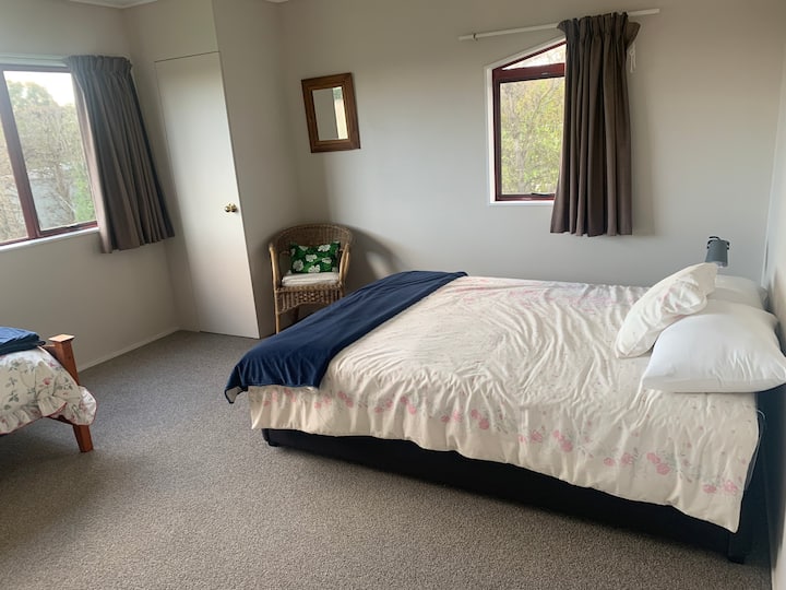 Este dormitorio tiene una cama tamaño queen y una cama individual. Vista del pico Te Mata al otro lado del huerto desde este dormitorio.