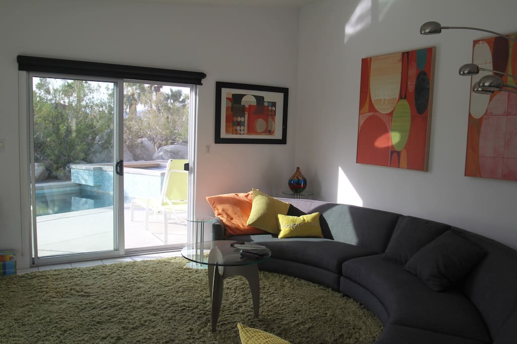 Circular couch in living space, overlooks the pool and 1400 sq ft patio
