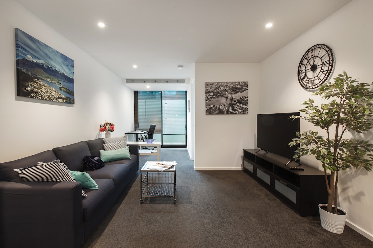 Priestranný obývací priestor je vybavený plyšovou trojmiestnou pohovkou oproti 46-palcovej inteligentnej televízii.