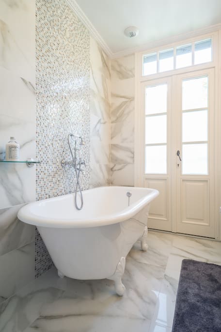 Luxury white marble main bathroom with clawfoot bath