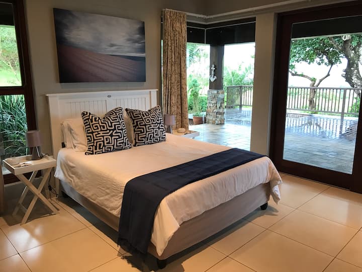 חדר שינה 1: מיטת קווין סייז, דלת הזזה שנפתחת למרפסת עם נוף לים, מיזוג אוויר וחדר רחצה צמוד 