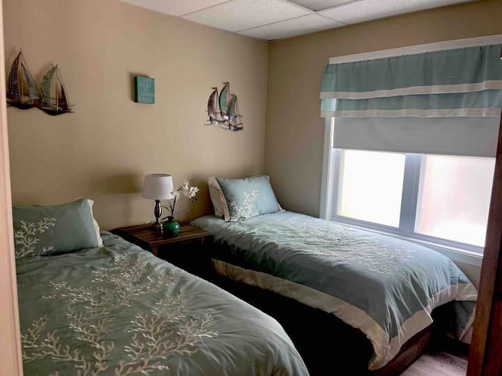 The second bedroom has two twin beds, a TV for streaming with FREE Netflix and a bedside table with a built in outlet for charging your devices.