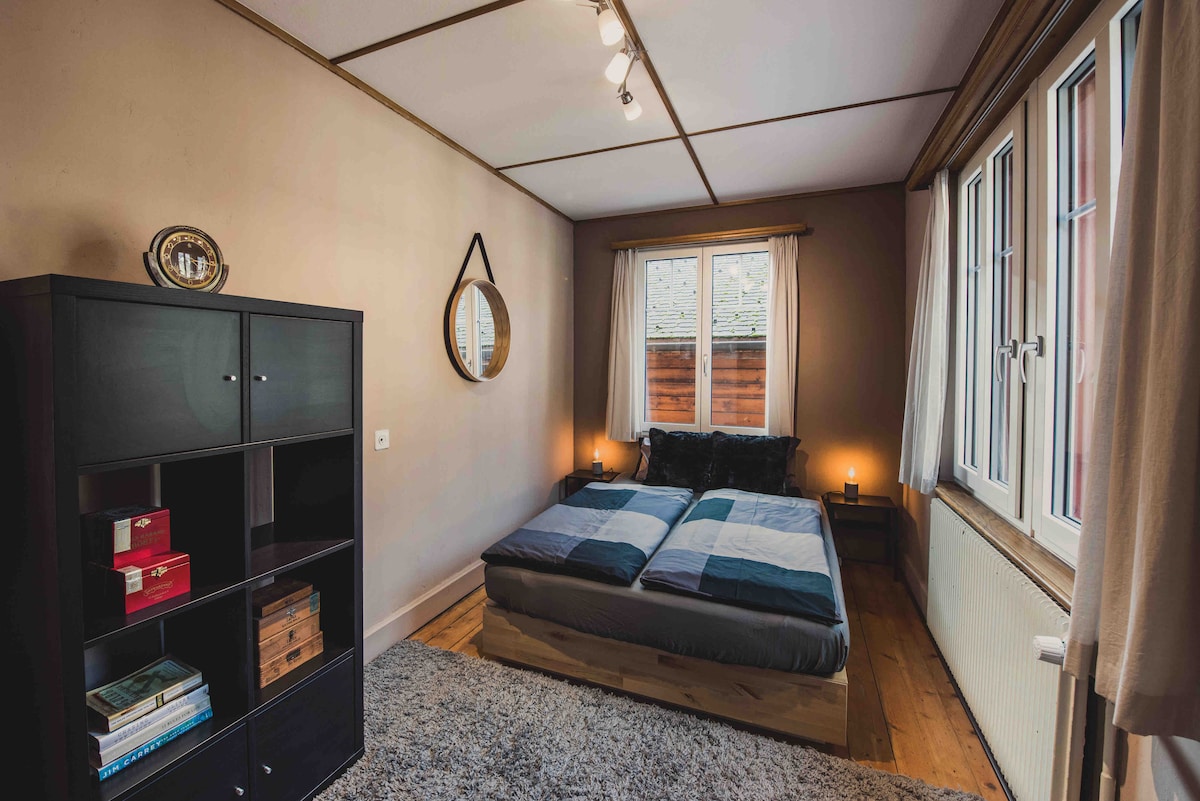 Chumba cha kulala 1 - Ghorofa ya Kwanza
Kabati la Vitanda Viwili, Kiti cha Kukaa, Hifadhi ya Nguo za Cubby, Meza mbili 
za Usiku na Taa za Kusoma
Madirisha ya Barabara Kuu yanayoelekea Rothorn.