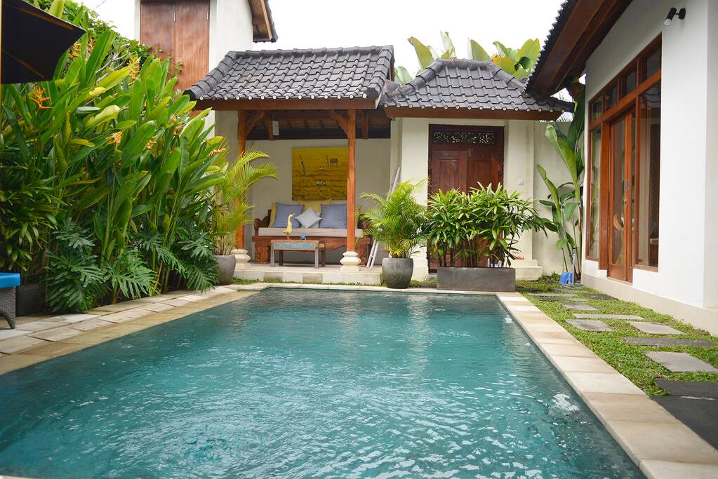 There is a lounging area beside the pool.