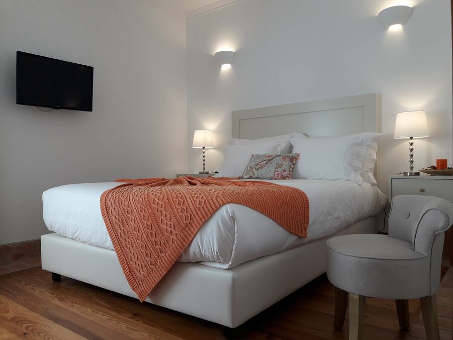 Quarto de casal com ambiente minimalista, em tons de laranja.