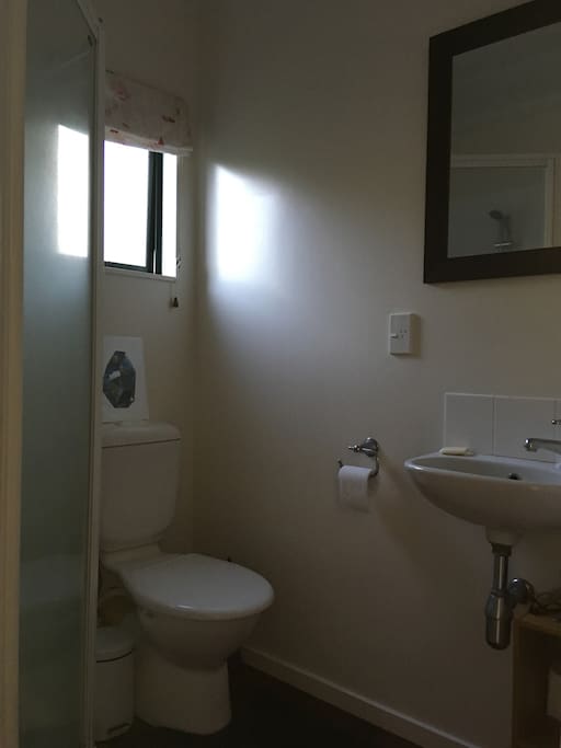 Private bathroom across from bedroom with spacious shower.